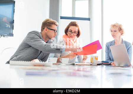 Creative businesspeople analyzing documents at desk in office Stock Photo