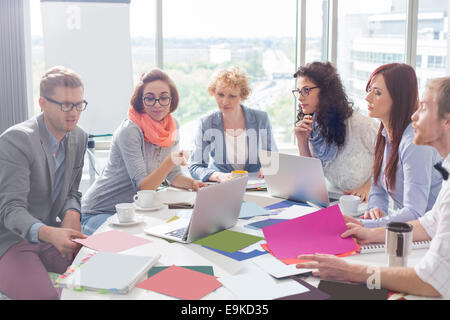Creative business colleagues analyzing photographs at conference table in office Stock Photo