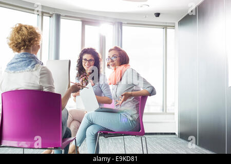 Businesswomen discussing in creative office Stock Photo