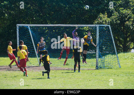 Youth football players defending a high ball in front of the goal, Cape Town, South Africa Stock Photo