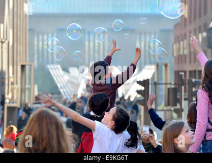 London, England, UK. Children playing with bubbles at the end of Millennium Bridge Stock Photo