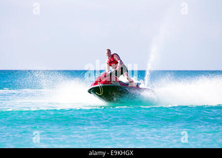 Young guy cruising on the atlantic ocean on a jet ski Stock Photo