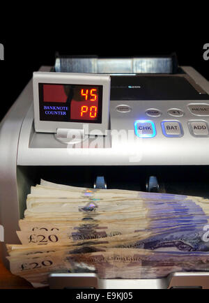 Money counter with British pound sterling in tray. Stock Photo