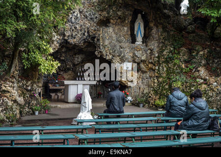 Pilgrims praying in front of the grotto at the Espace Bernadette Soubirous at Nevers, Burgundy, France Stock Photo