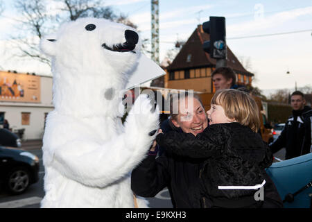 Copenhagen, Denmark. 29th October, 2014. A homeless polar bear gives a high five to a kid and his mother. This happening was organized by World Wildlife Foundation (WWF) in order to point out that the global warming has serious consequences for the arctic wildlife. WWF raise the issue because the UN climate panel meeting – also in Copenhagen – next Sunday shall publish it’s Summary Report with recommendation for actions to global leaders Credit:  OJPHOTOS/Alamy Live News Stock Photo