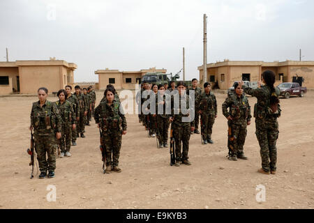 Kurdish People's Protection Unit YPG ( Male) and YPJ ( Female) fighters taking part in a recruitment ceremony in a training camp in Al Hasakah or Hassakeh district known as Rojava the de facto Kurdish autonomous region originating in and consisting of three self-governing cantons in northern Syria Stock Photo