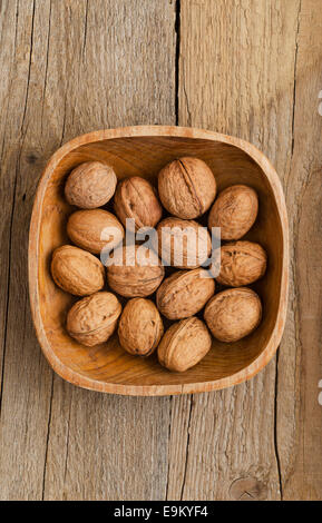 Walnuts in rustic bowl over wooden table Stock Photo