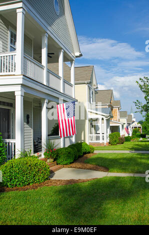 American Flags hang from the front porches in a neighborhood of upscale, Victorian homes in celebration of the upcoming holiday. Stock Photo