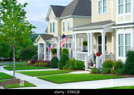 American Flags hang from the front porches in a neighborhood of upscale, Victorian homes in celebration of the upcoming holiday. Stock Photo