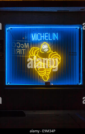 McCoy Tire dealer in Modesto California USA with a neon running Michelin Man Bibendum in the front window Stock Photo