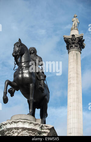 LONDON, United Kingdom — The equestrian statue of King Charles I in the foreground, with Nelson's Column rising prominently in the background at Trafalgar Square. This scene captures two iconic monuments spanning different eras of British history in one of London's most famous public spaces. Stock Photo