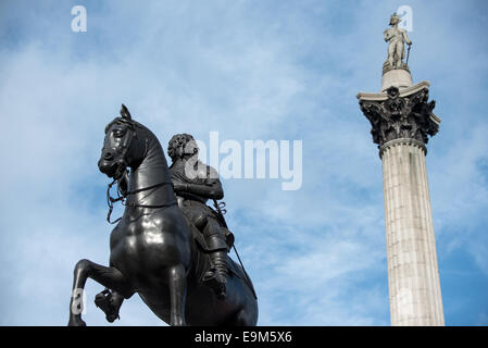 LONDON, United Kingdom — The equestrian statue of King Charles I in the foreground, with Nelson's Column rising prominently in the background at Trafalgar Square. This scene captures two iconic monuments spanning different eras of British history in one of London's most famous public spaces. Stock Photo