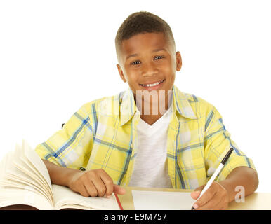 Handsome Eleven Year old African American Boy Doing Homework and Smiling on a White Background Stock Photo