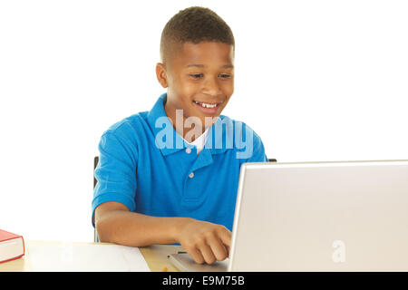 Handsome Eleven Year old African American Boy Doing Using a Laptop Computer and Smiling on a White Background Stock Photo