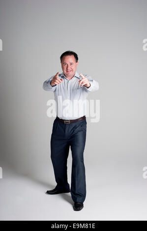 Man in business suit pointing and smiling, you have got it Stock Photo