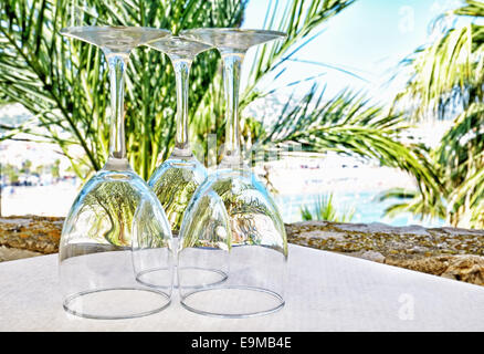 Wineglasses prepared on outdoors table in sunny day Stock Photo