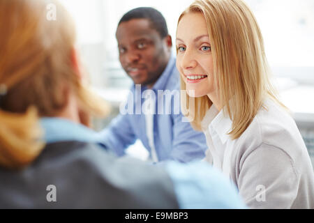 Smiling businesswoman between her co-workers Stock Photo