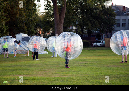 People Zorbing and Playing Football on Clapham Common at Sundown - London UK Stock Photo