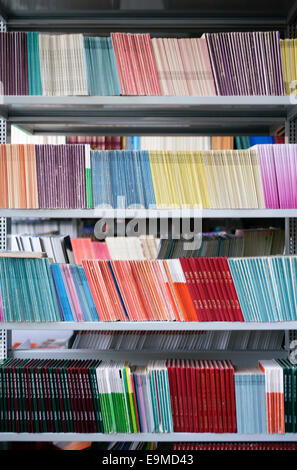 Many colorful books arranged on bookshelves Stock Photo