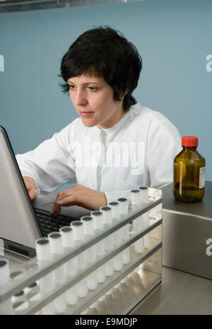 Technician working on laptop in laboratory Stock Photo