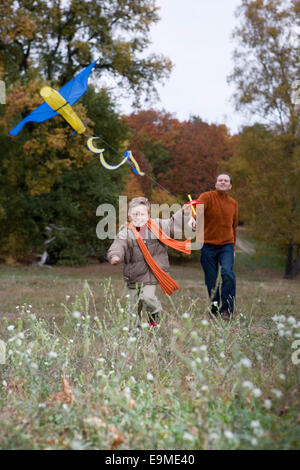 Father and son flying kite in autumn Stock Photo