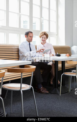 Business colleagues using a digital tablet during a business lunch Stock Photo