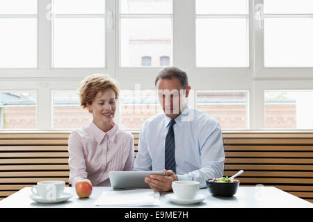 Business colleagues using a digital tablet during a business lunch Stock Photo
