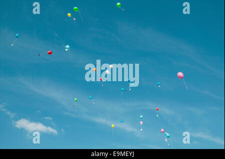 Low angle view of balloons with messages in mid-air against sky Stock Photo