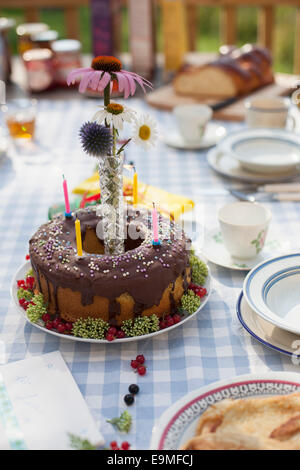 Decorated birthday cake on dining table at yard Stock Photo