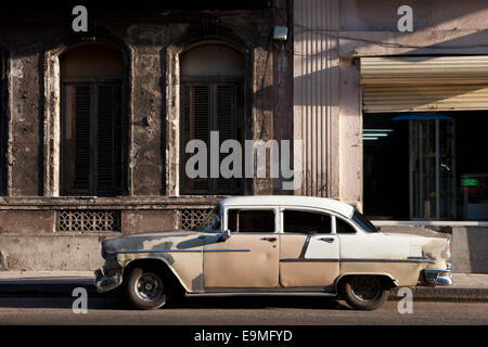 Old vintage car parked on street outside building Stock Photo