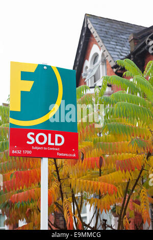 Agents Sold sign outside a London Townhouse with tree in autumn colors. Stock Photo