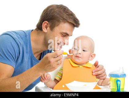 father feeding baby son by healthy food Stock Photo