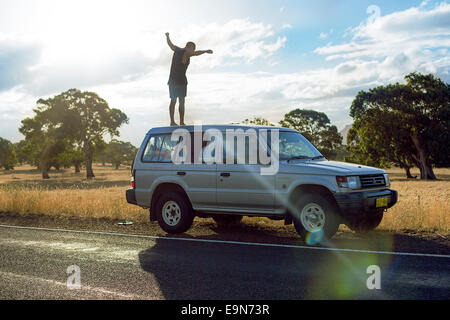 Young man balancing on car, Grampians Nature Reserve, Australia Stock Photo