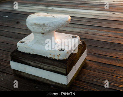 Large metal bollard on wooden decking Stock Photo