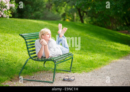 Young woman laying on bench Stock Photo