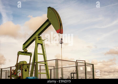 oil rig pumping on cloudy sky background Stock Photo