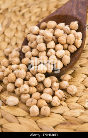 dried white chickpeas ceci on the wooden spoon Stock Photo
