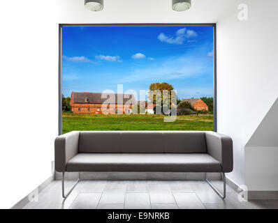 Empty room with sofa and beautiful landscape view through window. Stock Photo