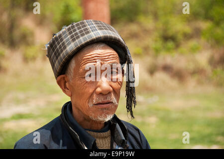 Close-up portrait of an elderly Buyei (Bouyei) man wearing a tasselled plaid hat, Guizhou Province, China Stock Photo