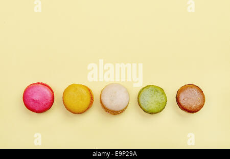 Colorful and tasty  French Macarons on yellow background.Top view. Stock Photo