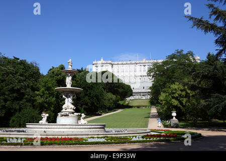 Flowers and Fuente de las Conchas fountain in Campo de Moro gardens, Royal Palace behind, Madrid, Spain Stock Photo