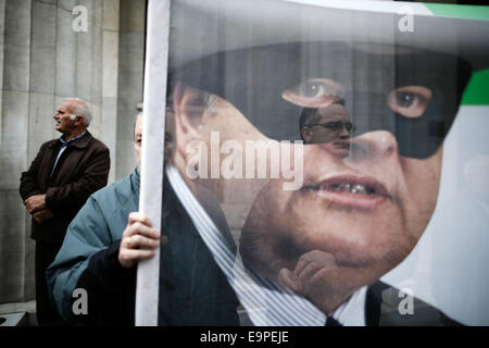 Thessaloniki, Greece. 31st Oct, 2014. An elderly small bondholder holds a banner with a caricature of Greece's Deputy Prime Minister and Foreign Minister Evangelos Venizelos. On the occasion of World Savings Day about 50 small bondholders who suffered major losses during Greece's massive public debt writeoff on 2012, claim to have been tricked by the government and are demanding compensation. Thessaloniki, greece on October 31, 2014. Credit:  Konstantinos Tsakalidis/Alamy Live News Stock Photo