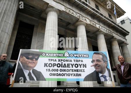 Thessaloniki, Greece. 31st Oct, 2014. Elderly small bondholders hold a banner with  caricatures of Greece's Deputy Prime Minister and Foreign Minister Evangelos Venizelos left and Greek Prime Minister Antonis Samaras that reads 'The Liar and the Thief' during a protest outside Bank of Greece branch. On the occasion of World Savings Day about 50 small bondholders who suffered major losses during Greece's massive public debt writeoff on 2012, claim to have been tricked by the government and are demanding compensation. Thessaloniki, greece on October 31, 2014. © Konstantinos Tsakalidis/Alamy Live Stock Photo