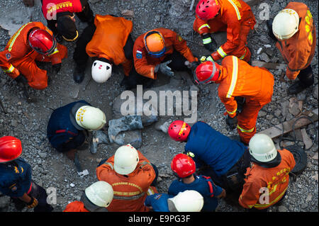 Jakarta, Indonesia. 31st Oct, 2014. Rescuers gather around the body of a victim during an operation in Jakarta, Indonesia, Oct. 31, 2014. It is believed that an archive building collapsed on Friday morning, causing four construction workers died, five workers seriously injured and two members of a rescue team slightly injured when searching victims. Credit:  Veri Sanovri/Xinhua/Alamy Live News Stock Photo