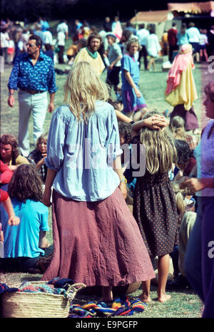 Rear view vintage photo of 1970 mother woman and girl 1970s seventies fashion watching people crowd at a music festival hippies at Barsham Fair in Beccles Suffolk England UK 1974 KATHY DEWITT Stock Photo