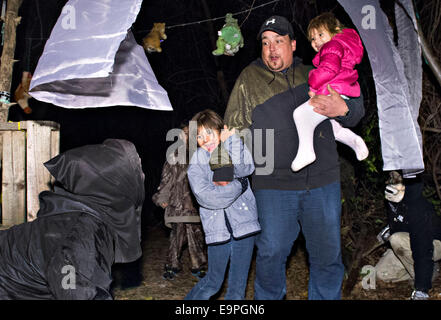 Montreal, Canada. 30th Oct, 2014. People react in the Halloween Haunted Woods on the Mohawk reserve of Kahnawake near Montreal, Canada, Oct. 30, 2014. More than 10 volunteers wearing frightening costumes scare and entertain visitors during the Halloween season here. The two-day activity also collects food and donations for the local food bank. Credit:  Andrew Soong/Xinhua/Alamy Live News Stock Photo