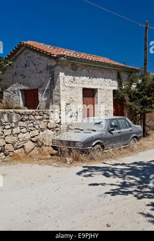 Old building with dust covered car in the Greek Island of Aegina, Greece. Stock Photo