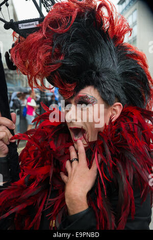 Man dressed in drag with a large wig and feathers during the Pride in London parade 2014, London, England Stock Photo