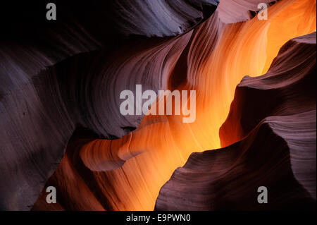 Sunlight penetrates into the darkness of a slot canyon in arizona Stock Photo