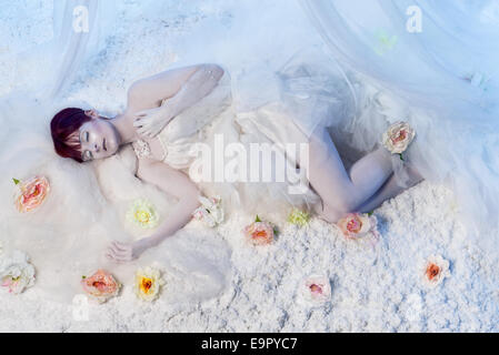 Beautiful sleeping woman in white winter scenery Stock Photo